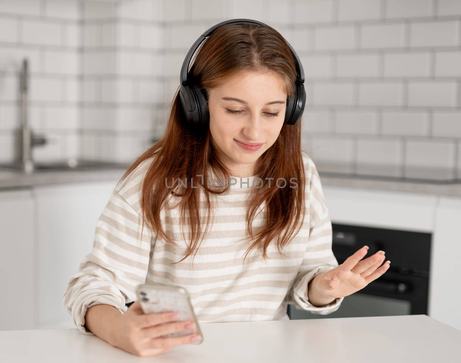 Girl In Headphones Listening To Music Through A Smartphone