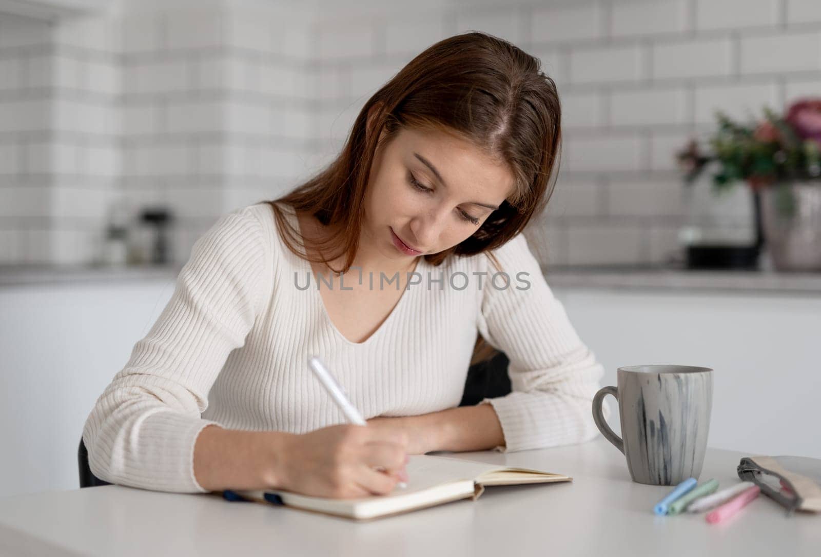 Teenage Girl Writing In Journal At Home