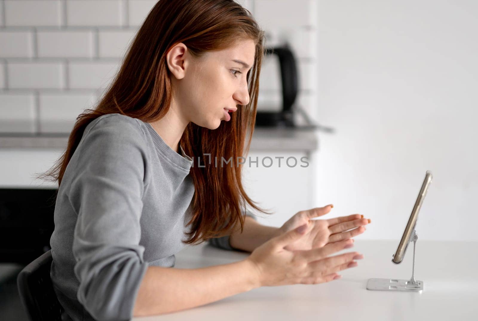 Unhappy Teen Girl Looking At Smartphone At Home