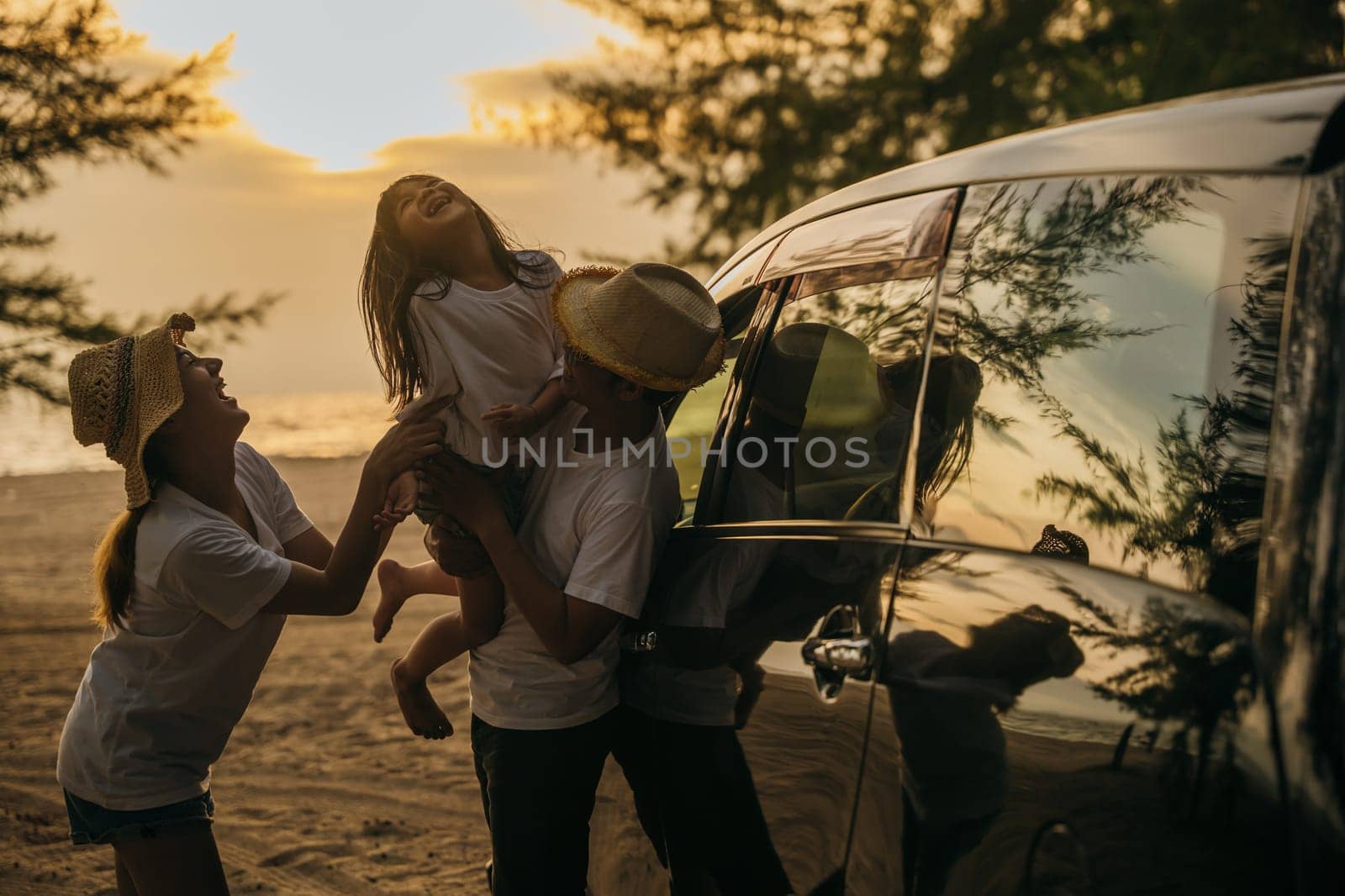 Asian family playing near car window at sunset feeling funny in holidays and relaxation together. Happy weekend travel enjoy summer at beach. summer vacation travel driving road trip concept