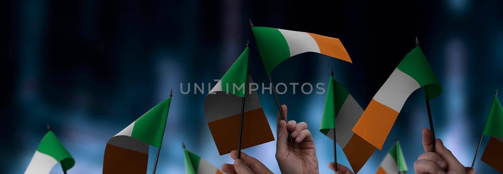 Ireland flags in their hands on a blurred urban background. The photo illustration was created without the use of artificial intelligence, only using Photoshop.