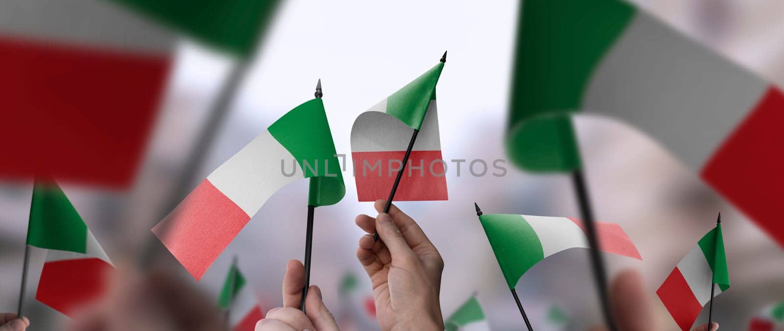 Italy flags in their hands on a blurred urban background. The photo illustration was created without the use of artificial intelligence, only using Photoshop.