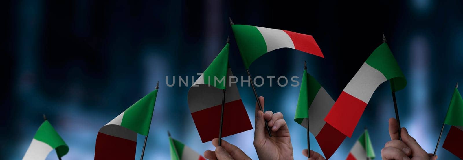 Italy flags in their hands on a blurred urban background. The photo illustration was created without the use of artificial intelligence, only using Photoshop.