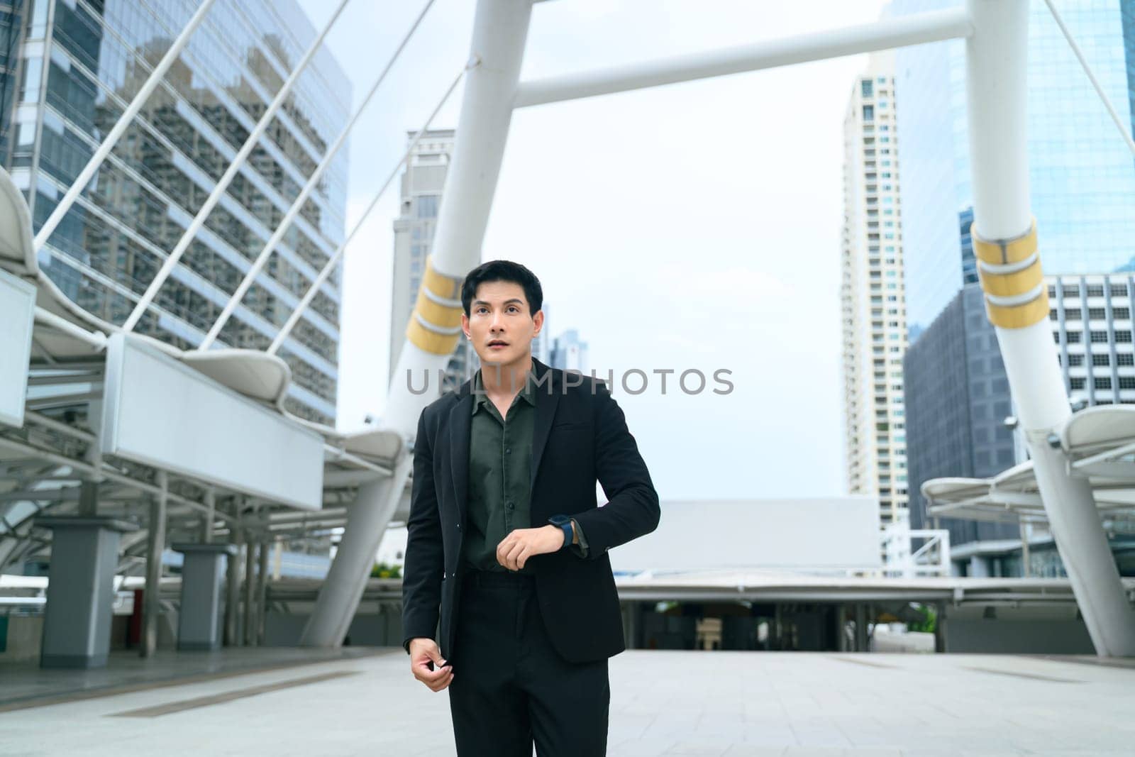 Confident asian businessman walking through a modern urban area.