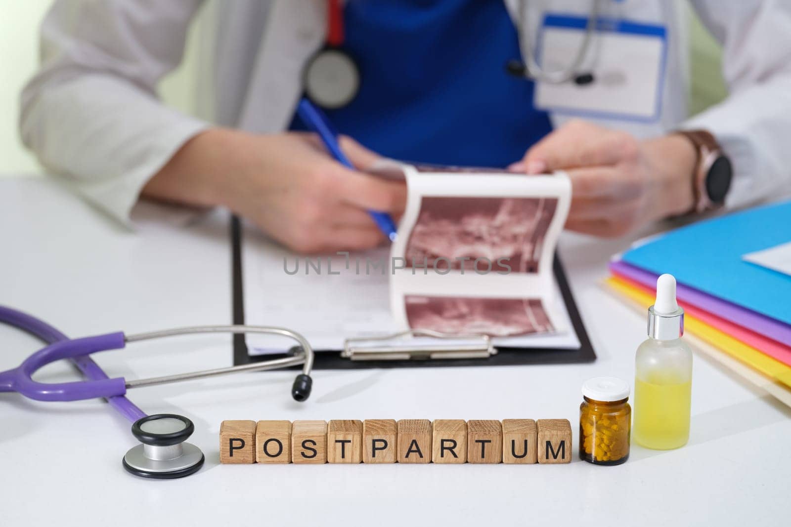 A healthcare professional reviews postpartum ultrasound images surrounded by medical tools and equipment