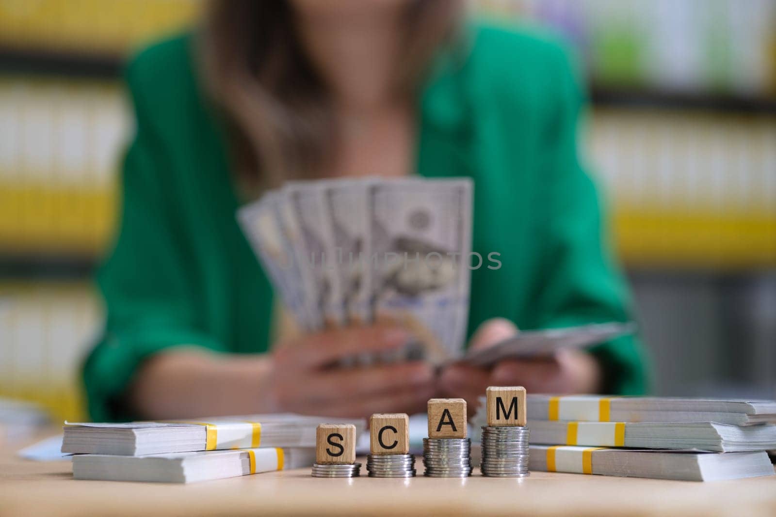 A compelling image showcasing the serious issue of financial scams with cash and blocks spelling 'SCAM'.