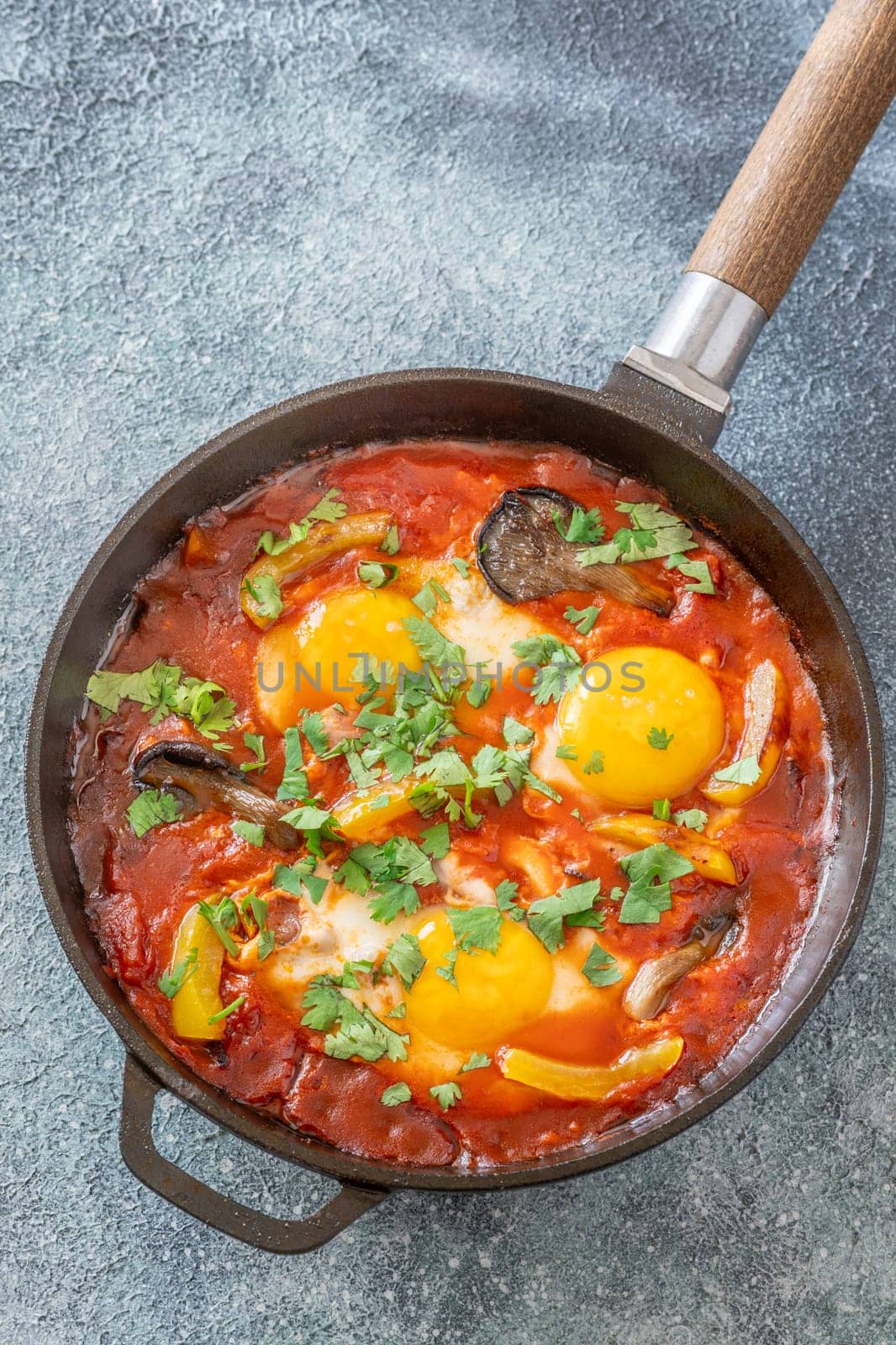 Eggs simmered in spiced tomato base with mushrooms, peppers, and fresh herbs