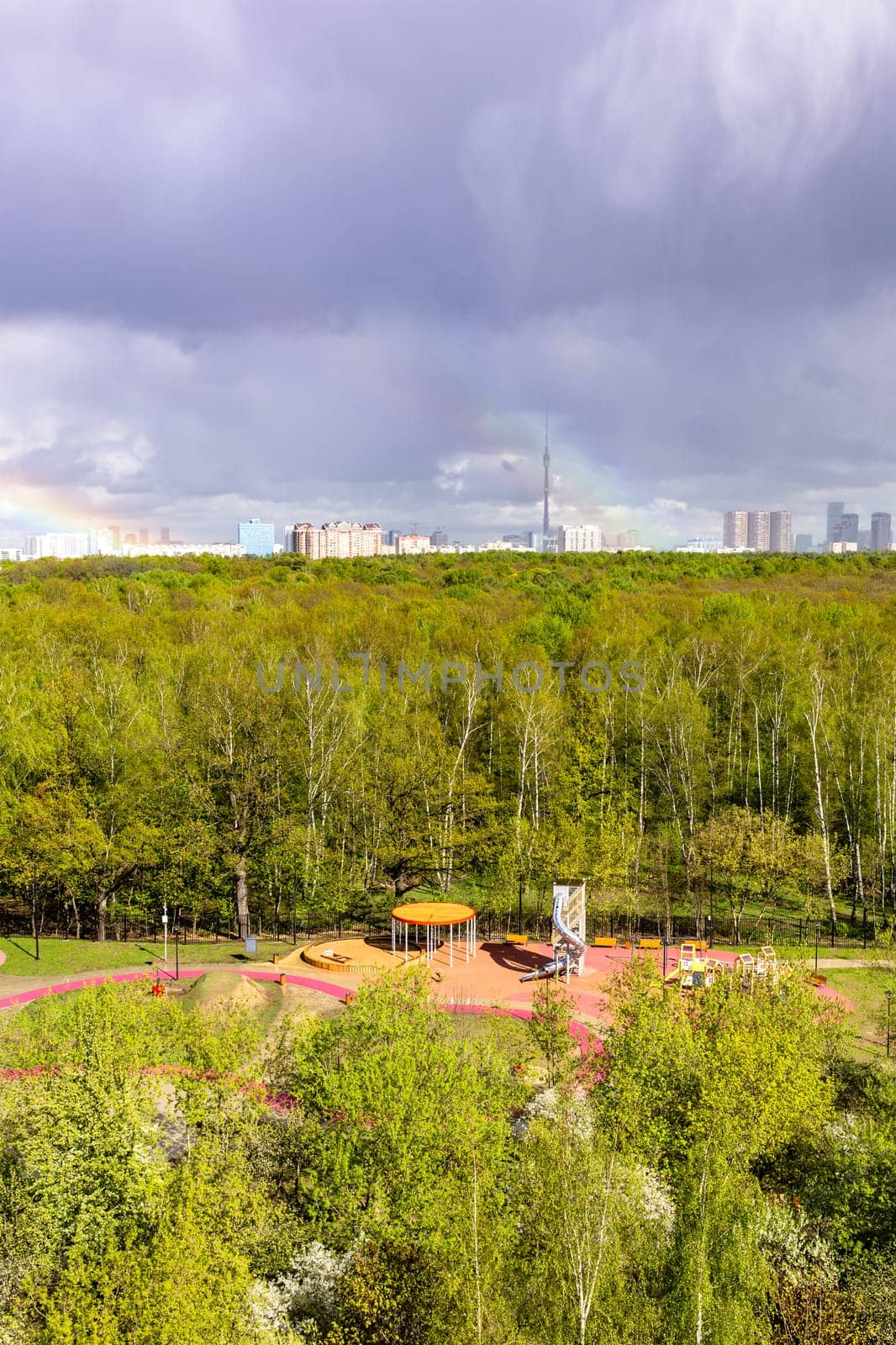 sunlit playground and green city park after rain on sunny spring day