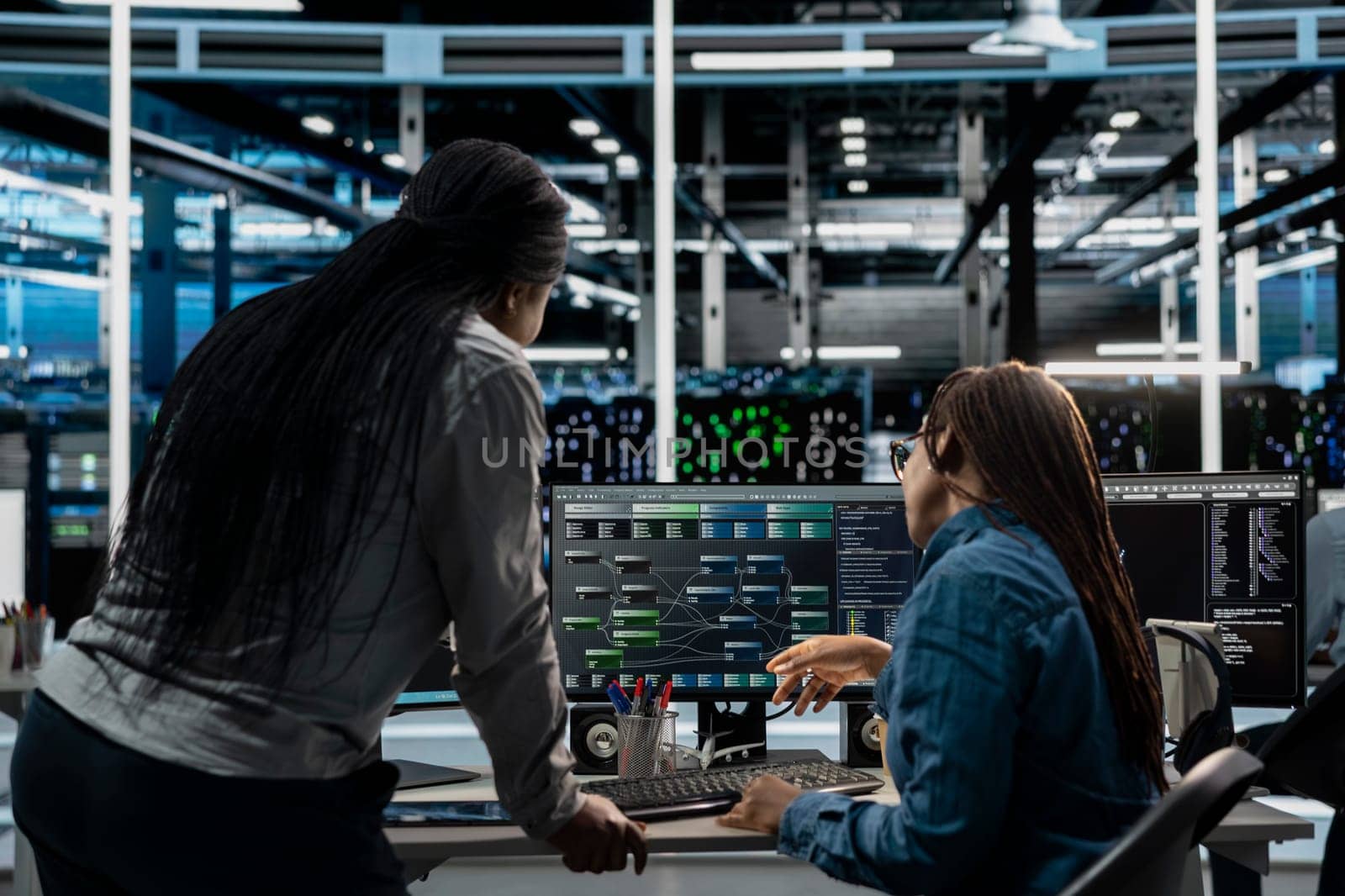 Server room manager overseeing work done by engineer using artificial intelligence to reduce downtime. Team leader supervising employee implementing AI driven solutions for data center equipment