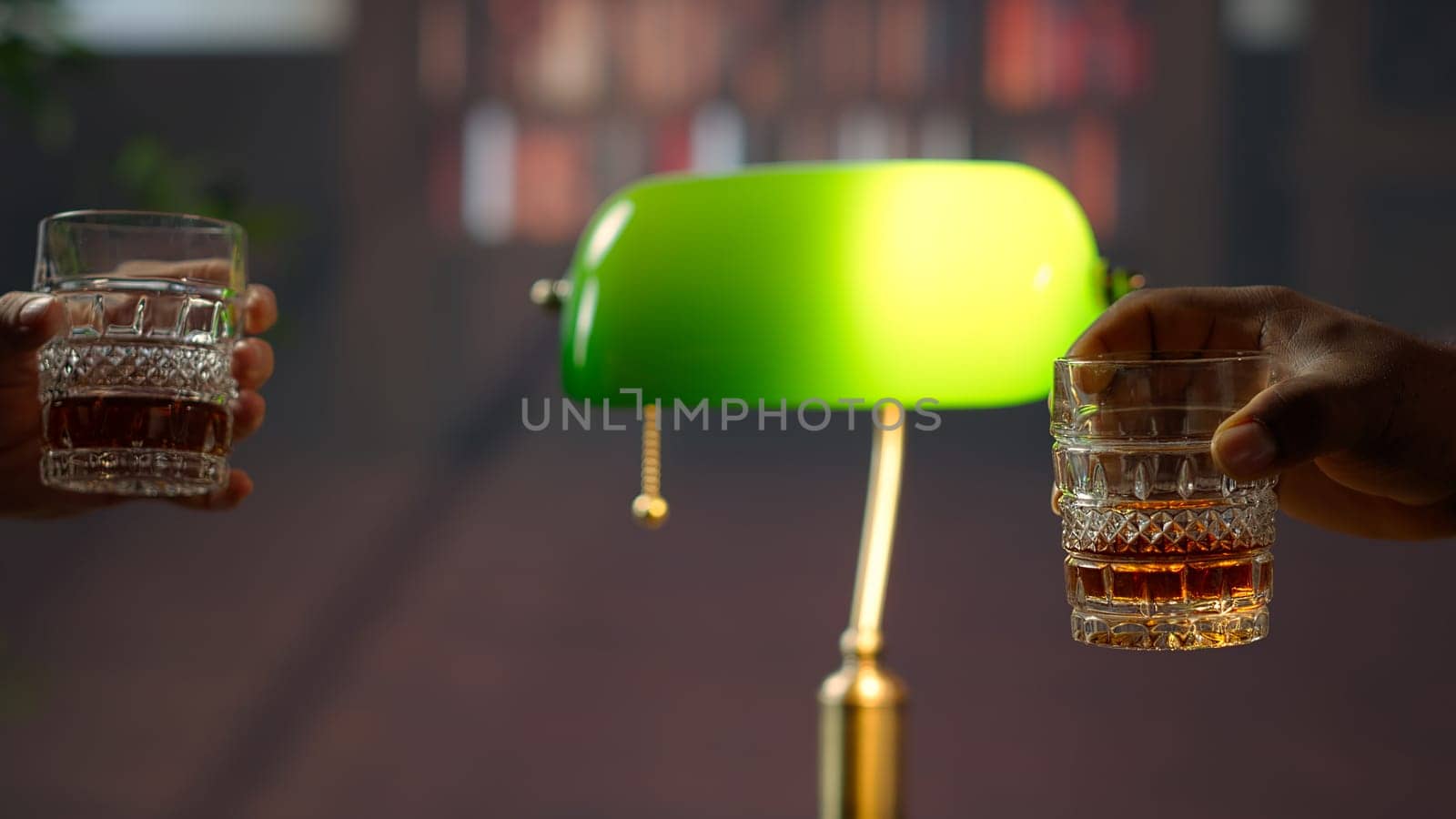 Businessmen clinking glasses of scotch and saying cheers, feeling excited about collaborating on making a fortune. Old money elite society members negotiate at social club. Close up. Camera B.
