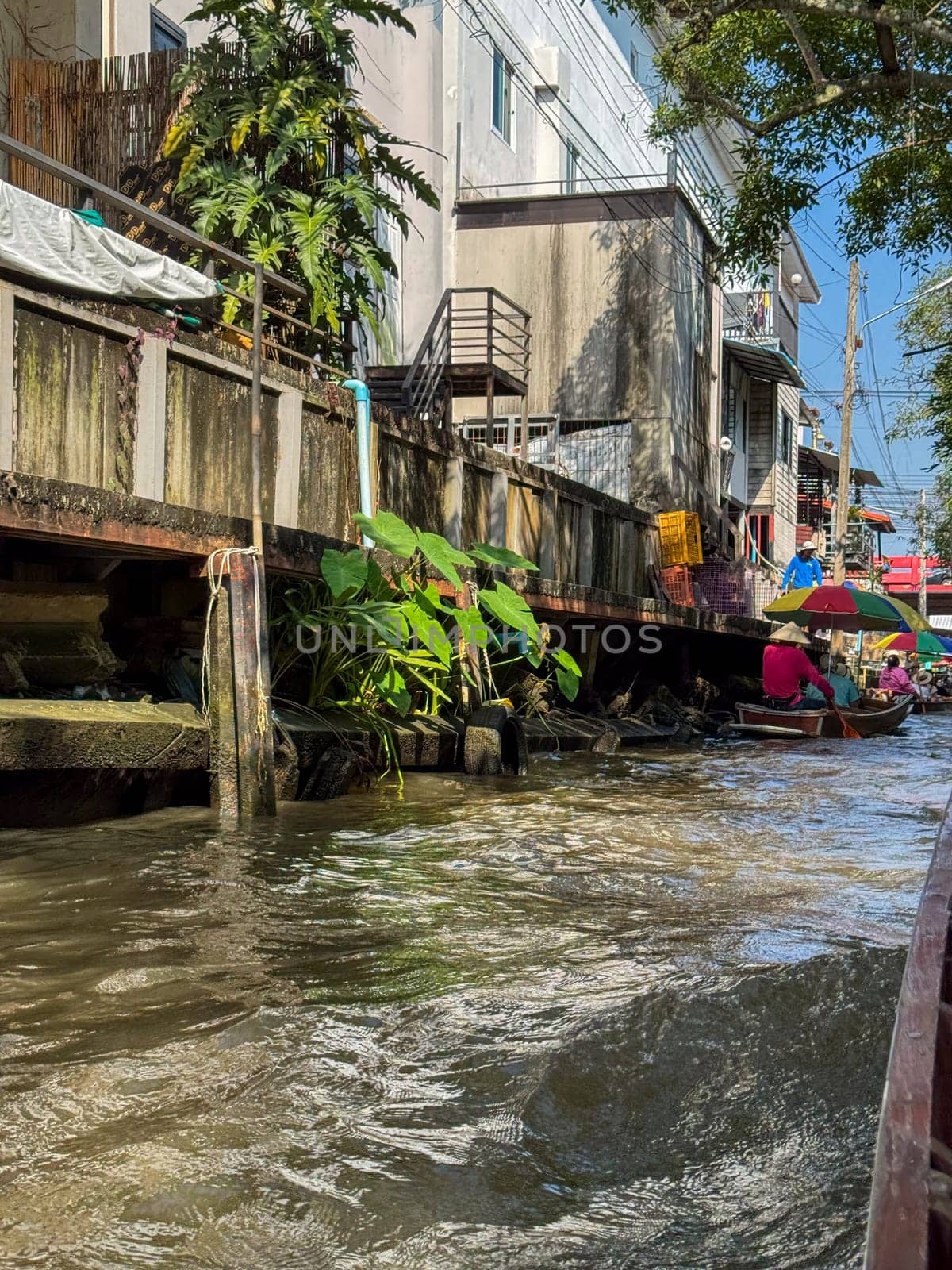 Bangkok, Thailand - November 12, 2024: Traditional floating market in boats full of produce, market vendors sell Thai food, fruits and seafood from boats. Thailand culture and tropical bazaar.
