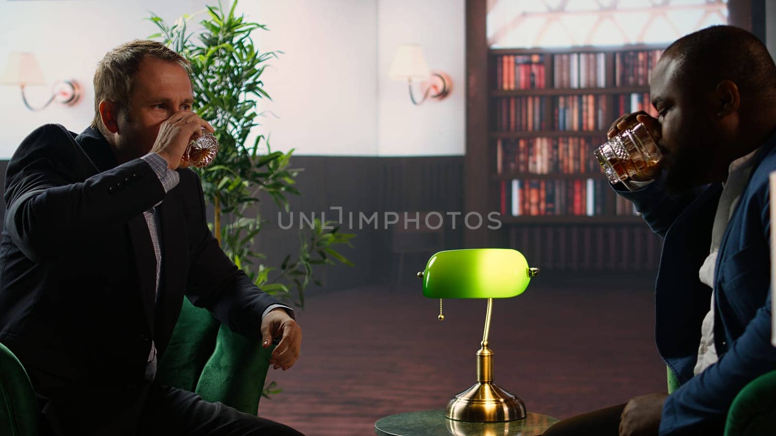 Upper class billionaires drinking whiskey glasses at the classy social club gathering, enjoying luxurious lifestyle with other old money society members. Elegant gentlemen. Camera A.