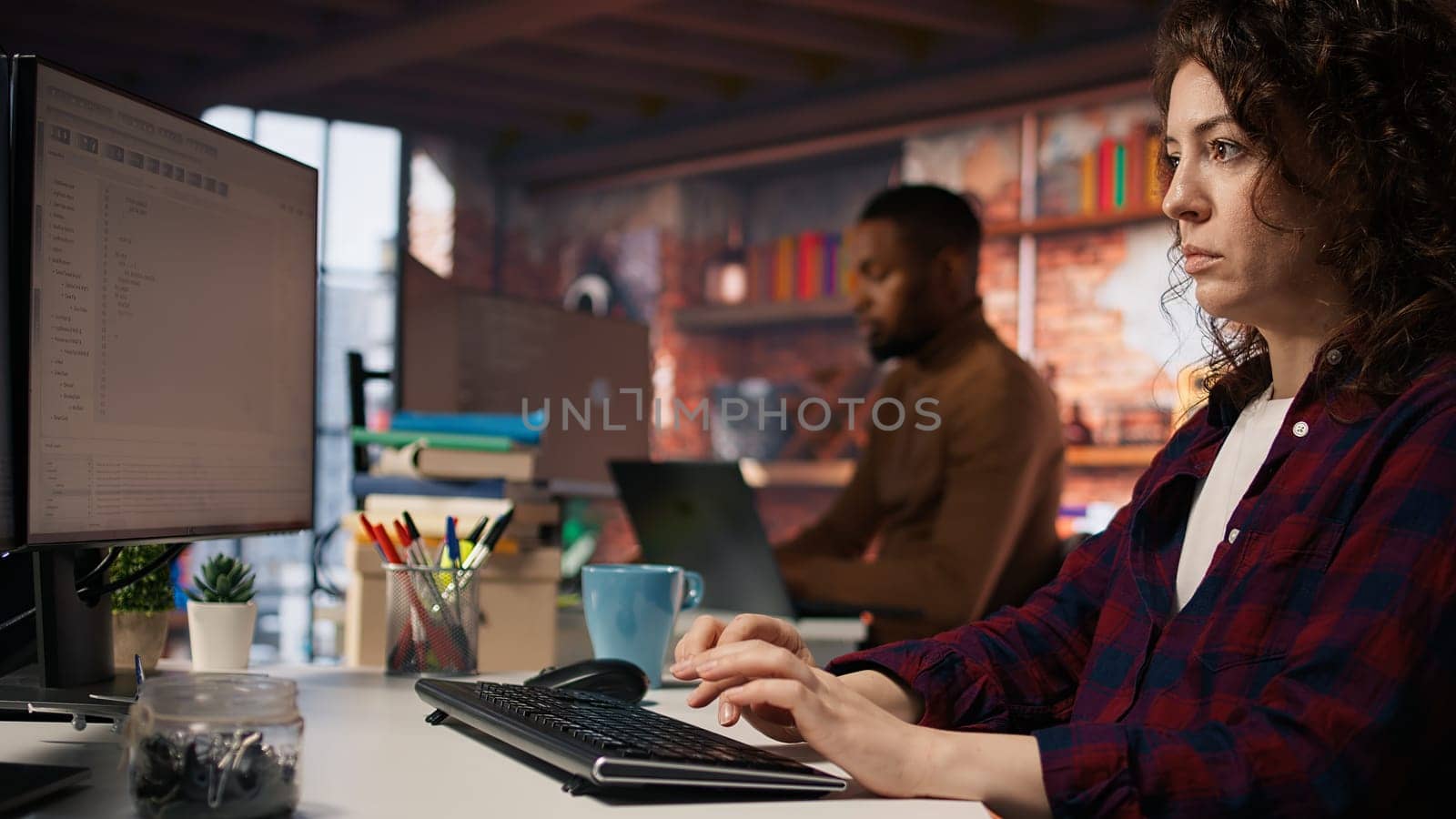 Company personnel sitting at desks in startup office, imputing data on computers. Man entering venture agency room holding laptop next to staff members in solving tasks during job shift, camera A
