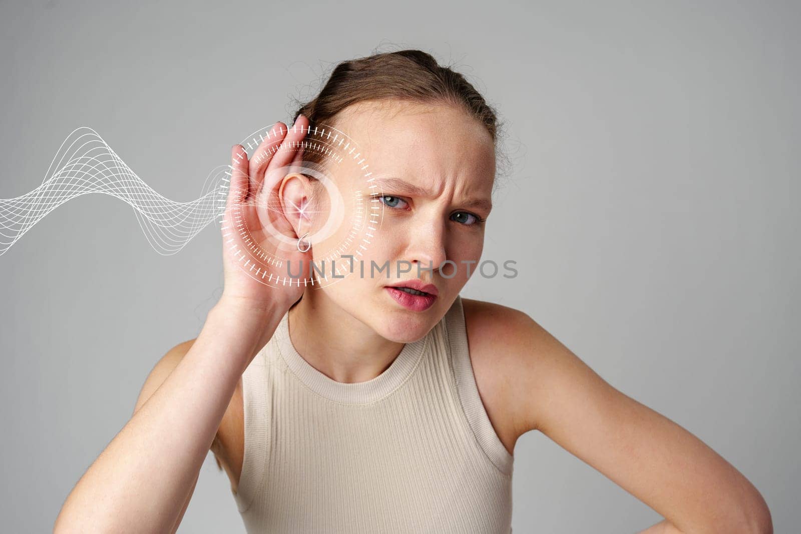 A young woman looks puzzled while leaning in with her hand on her ear. Surrounding her are visual representations of sound waves, indicating she's trying to hear better.
