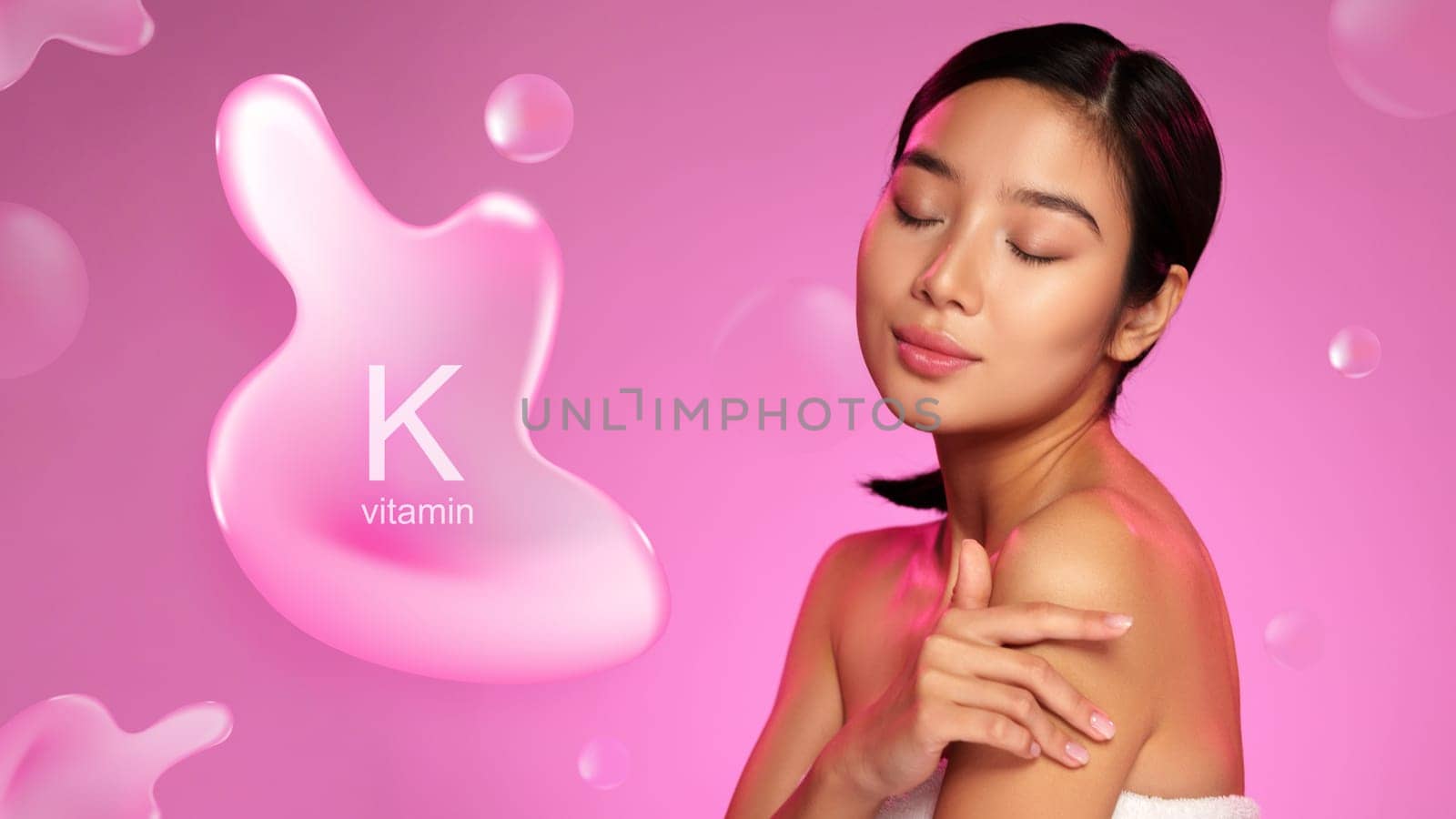 A woman gently applies a skin care product containing vitamin K, emphasizing its benefits for skin health. The vibrant pink backdrop enhances the focus on the product.