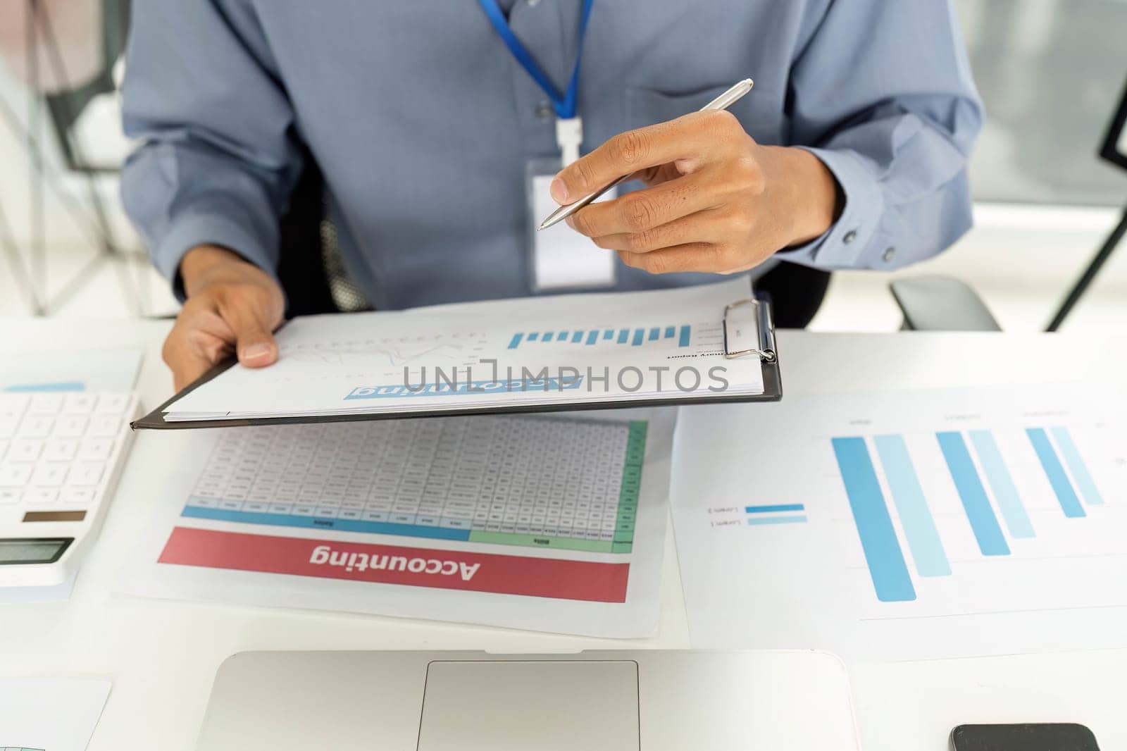A professional examines financial reports and documents, emphasizing accuracy in financial analysis in a modern office setting.