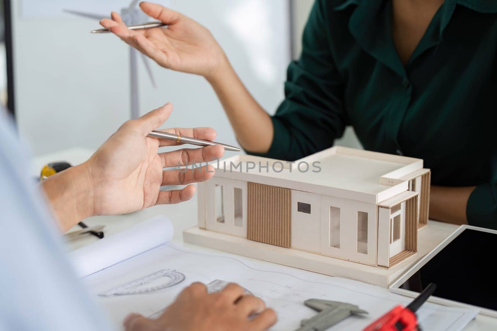 Architects collaborating on a sustainable building model, emphasizing environmental responsibility and innovative design.