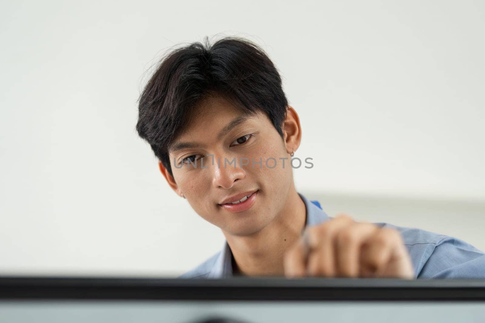 A young professional studies a digital board, displaying charts and graphs, while engaged in a data analysis presentation.