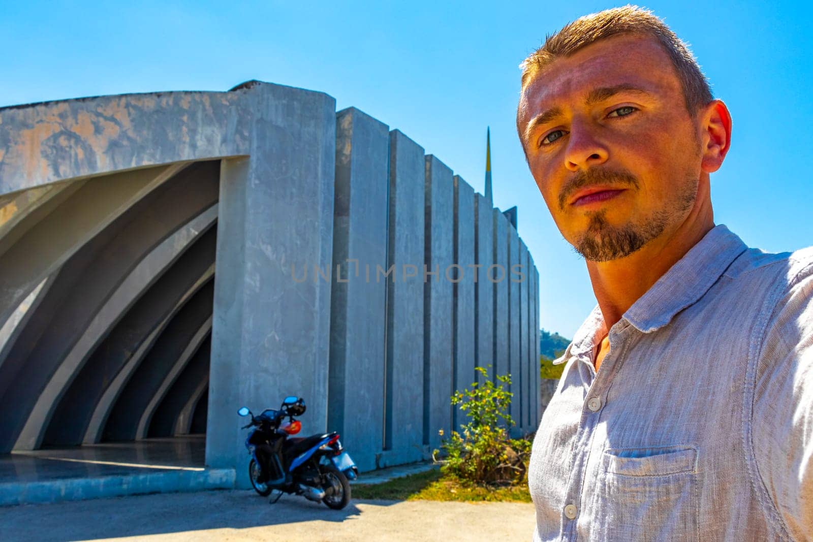 Man male handsome tourist traveler at the International Tsunami Museum and Memorial Park architecture building and structure in Khao Lak Amphoe Takua Pa Phang Nga Thailand.