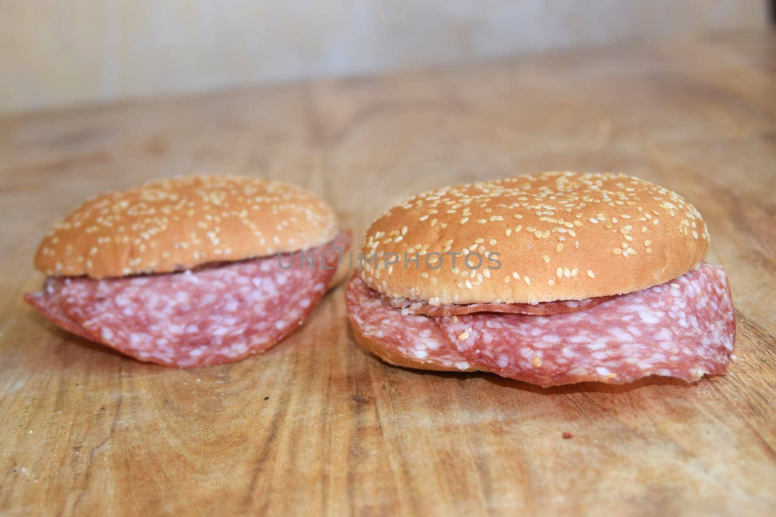 hamburger buns cut in half and filled with slices of salami