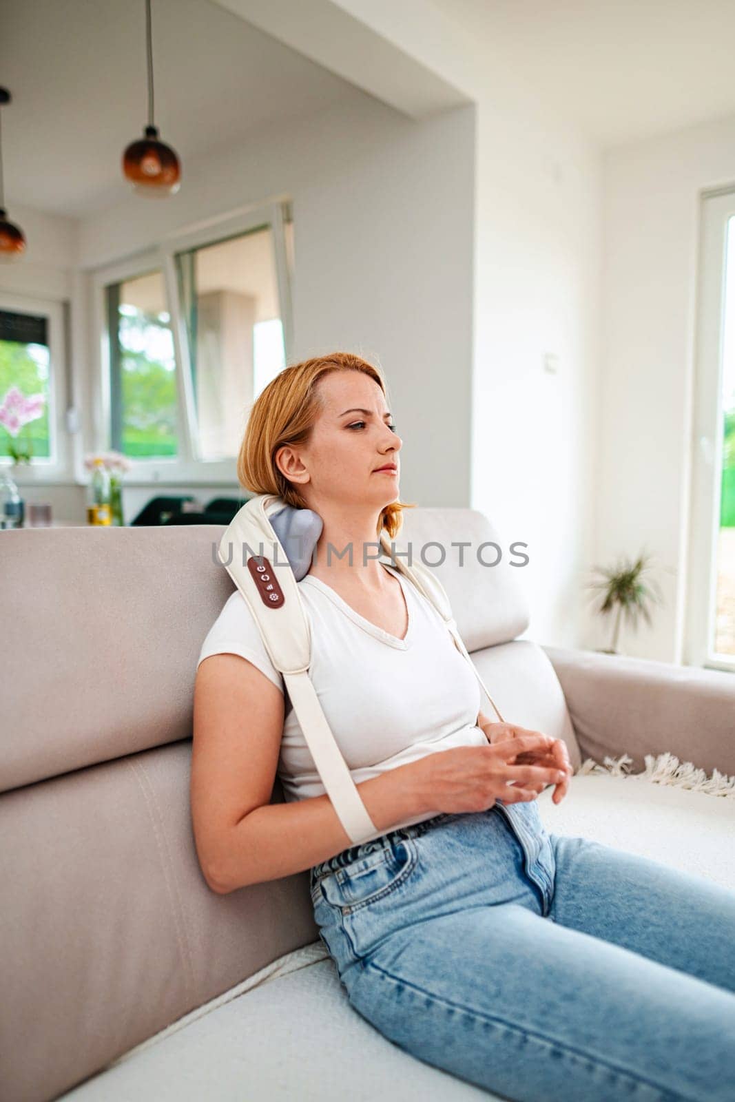 Woman enjoys tranquility while using a neck massager.