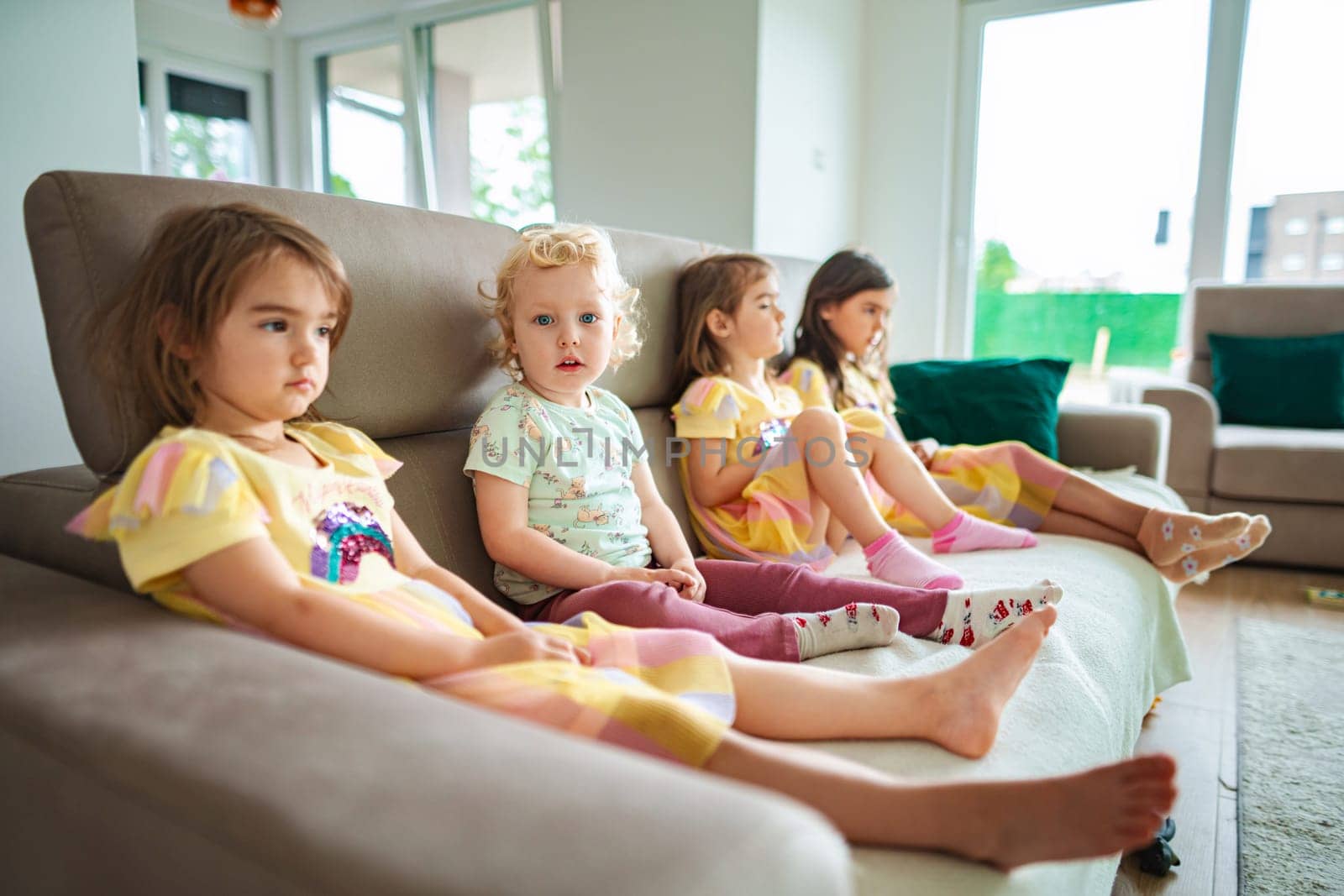 Kids enjoy a calm moment together in a sunlit space.