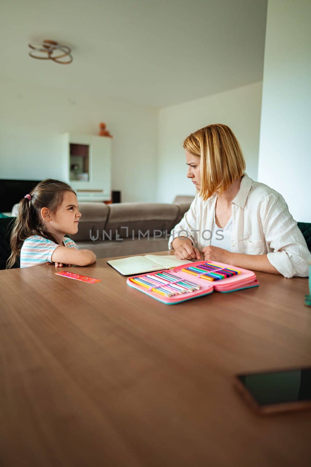 A woman shares artistic activities with a young girl.