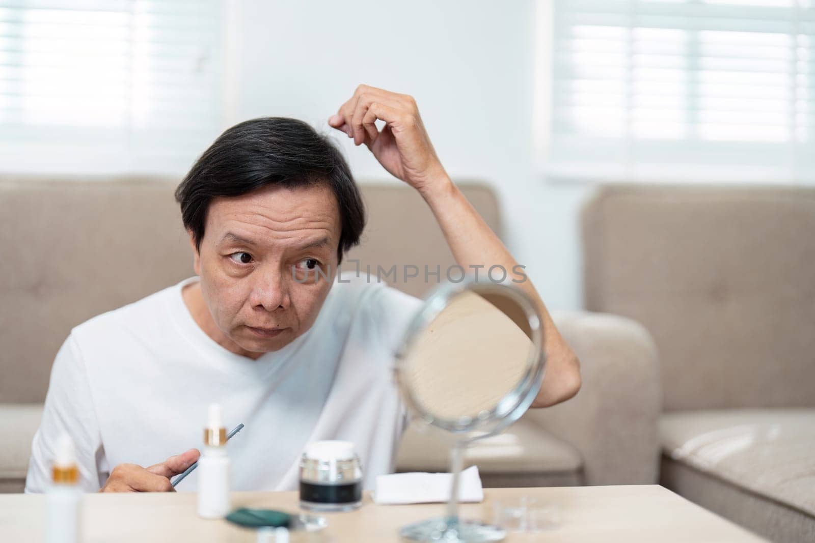 An elderly man carefully styles his hair while looking in the mirror, highlighting the importance of grooming and self-care in later years.