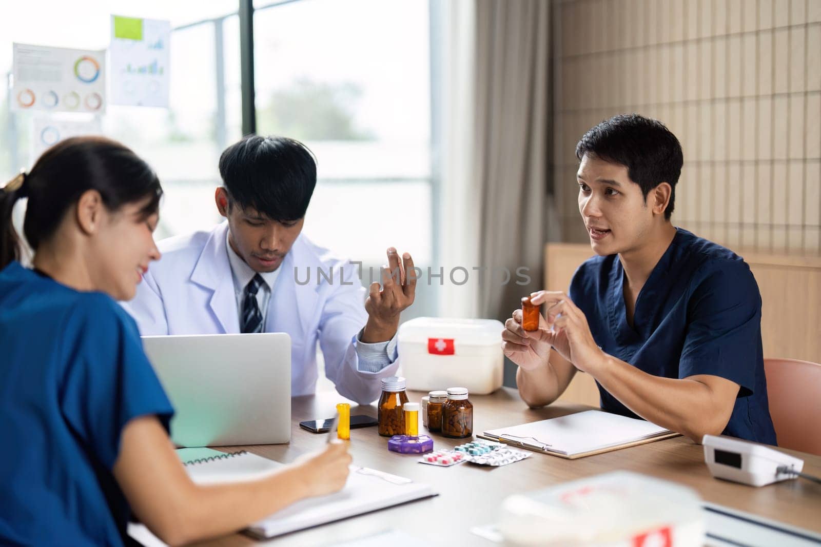 A dedicated team of healthcare professionals engages in a meeting to review patient medications and treatment plans, showcasing teamwork and effective communication in a clinical setting.