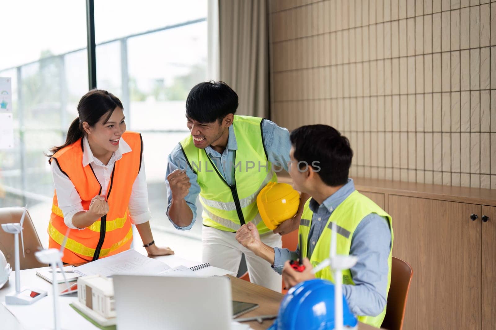 The engineering team celebrates their achievements in green technology, showcasing enthusiasm and teamwork in a modern office setting.