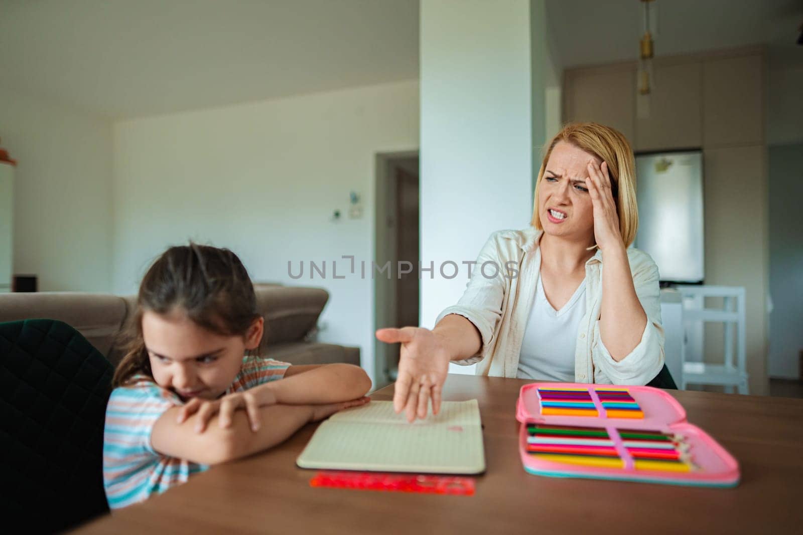 Child sits quietly parent shows stress and concern.