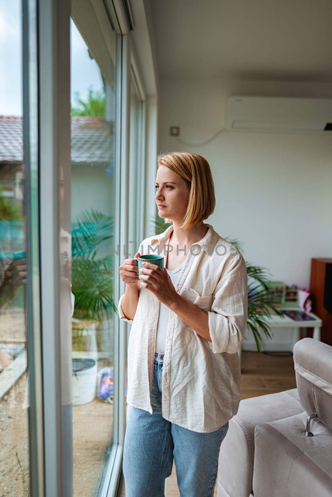 A woman enjoys a quiet moment while gazing outside.