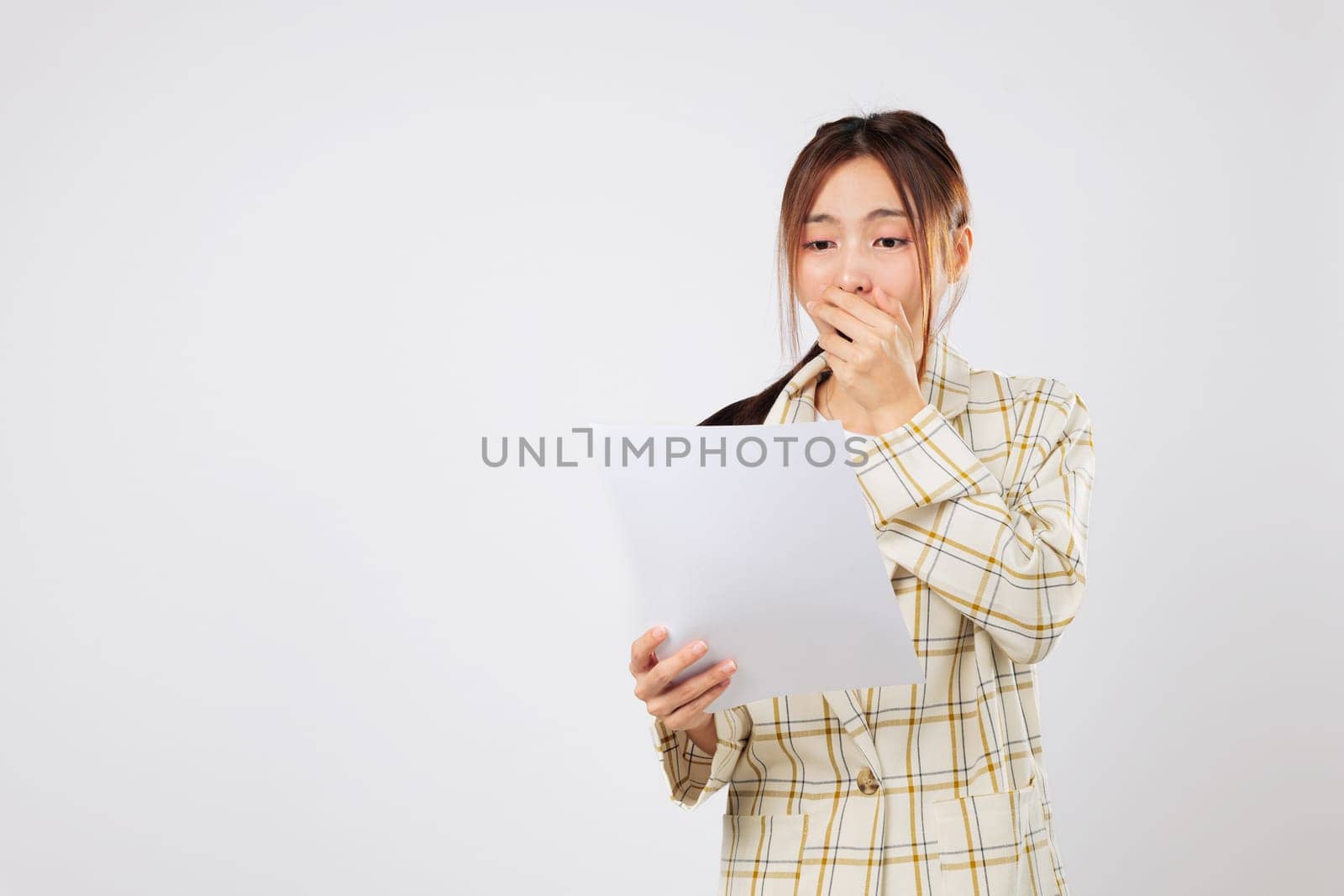 Holding multiple bills, she appears shocked by her financial situation, uncertain how to manage financial obligations without more income. isolated studio white background