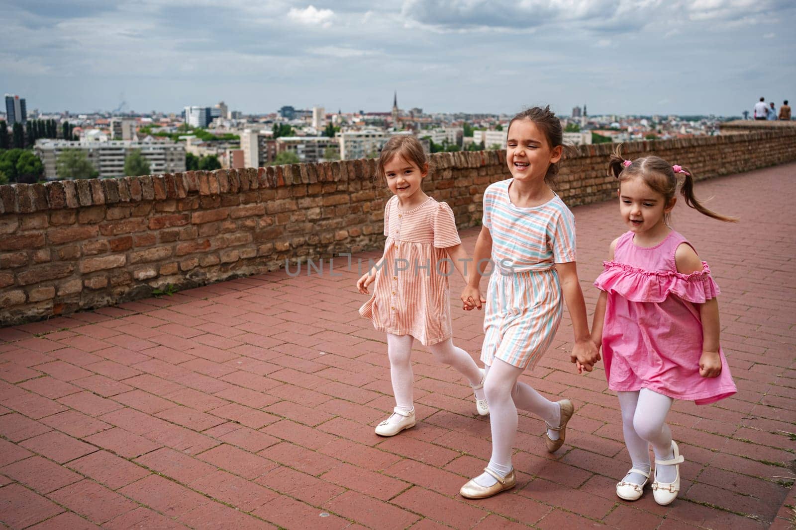 Joyful children hold hands while exploring the fortress grounds