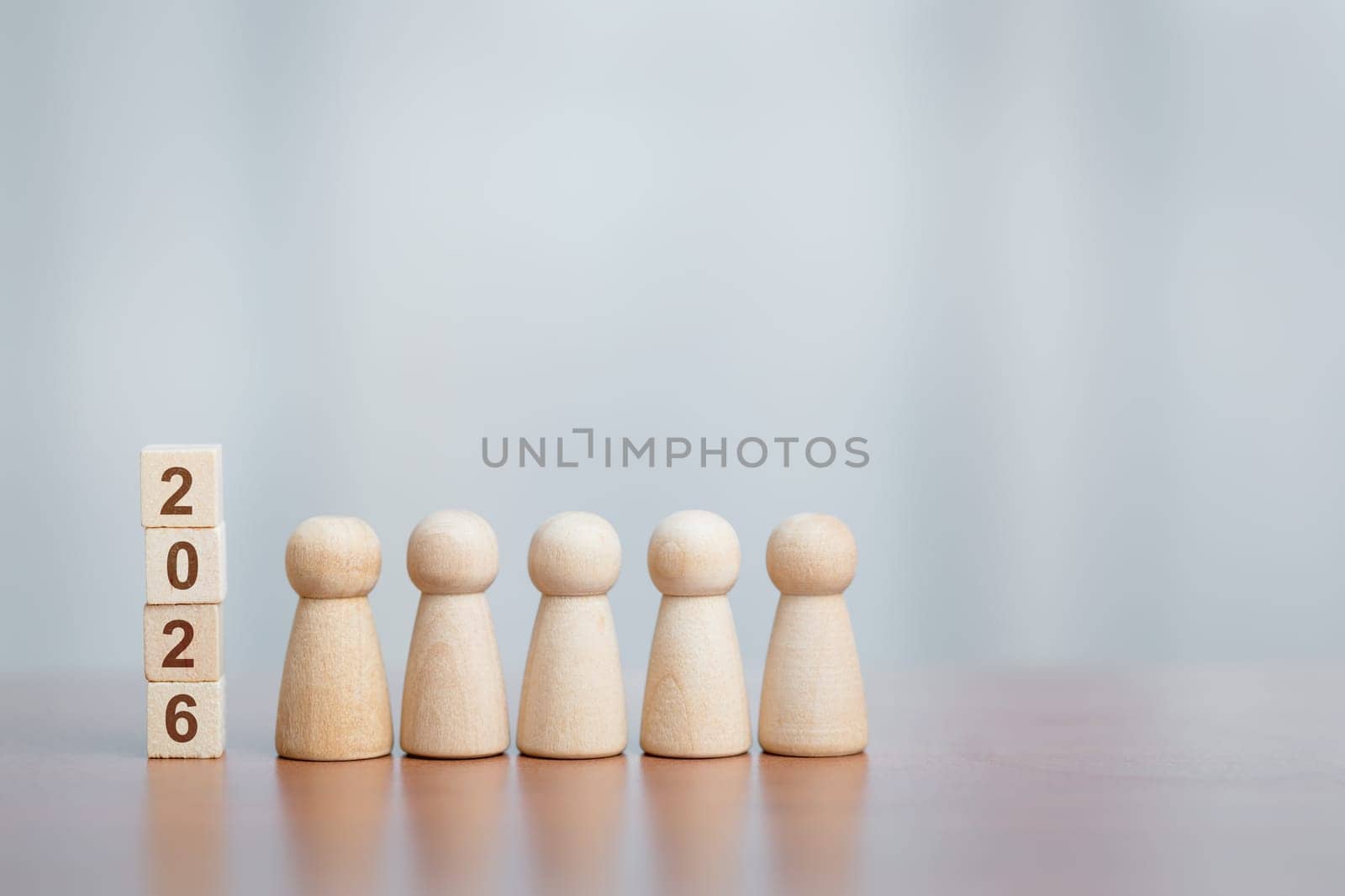 Five wooden figurines beside stacked blocks showing '2026'. Concept of future planning, teamwork, goal setting, leadership, and new year vision.