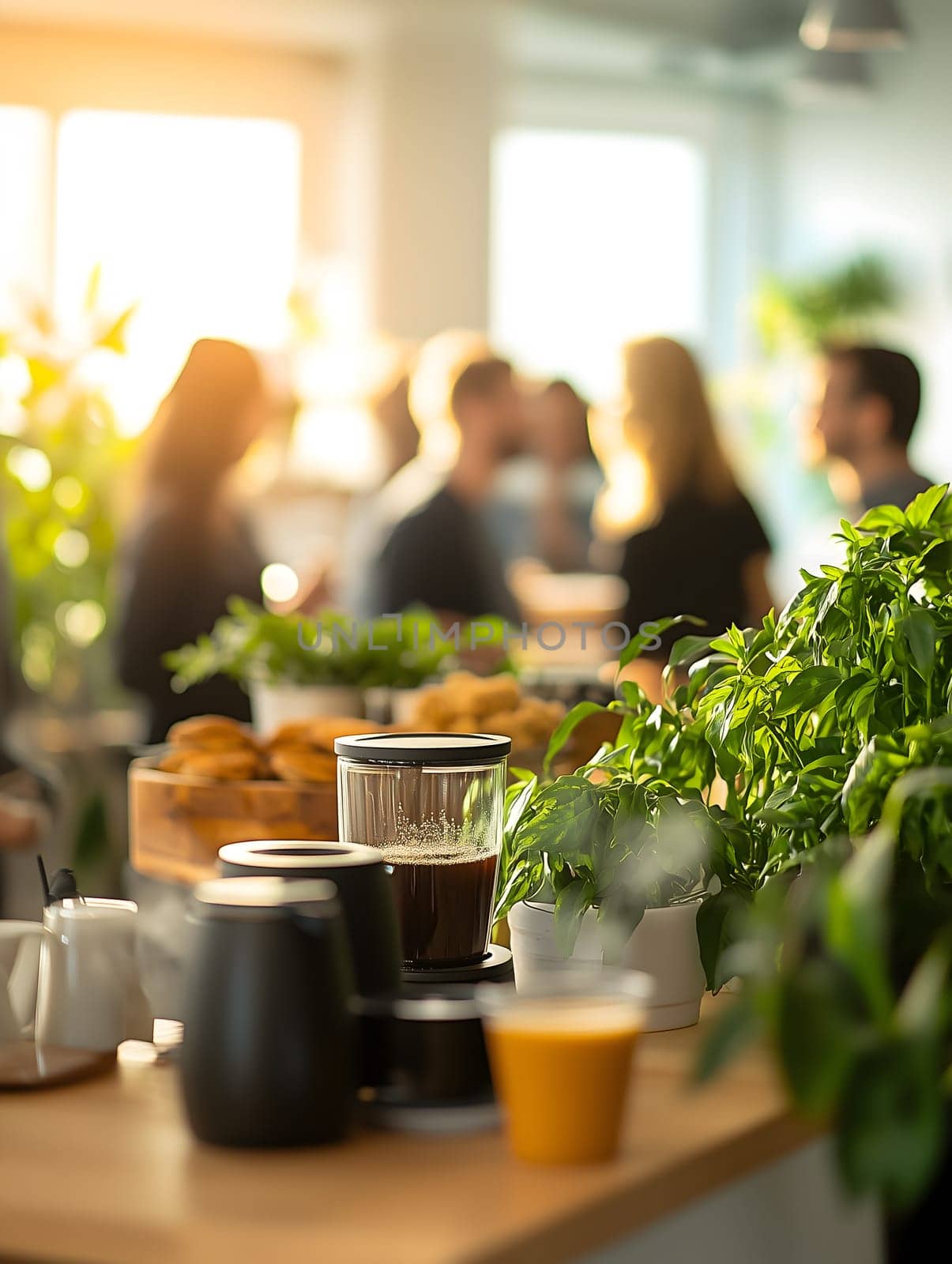 Vertical AI generated image of a cozy coffee break station in a bright office space. Coffee, juice, and plants in foreground with a blurred group of people socializing in the background.