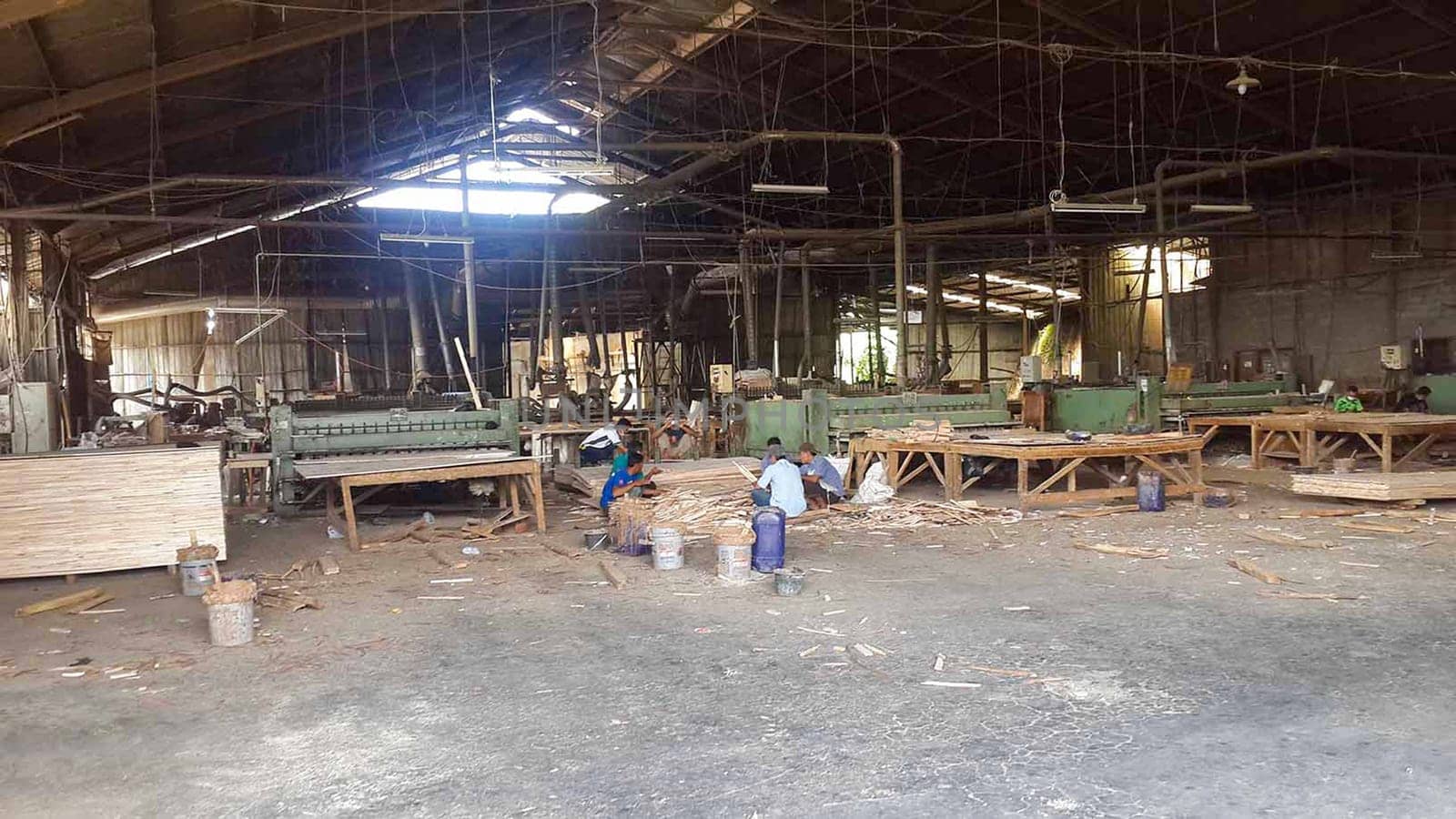plywood processing plant showcasing Industrial Warehouse Interior with Stacks of Materials and Machinery, warehouse featuring industrial equipment, materials, and wooden pallets, highlighting productivity and organization.