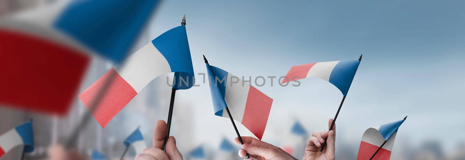 France flags in their hands on a blurred urban background. The photo illustration was created without the use of artificial intelligence, only using Photoshop.