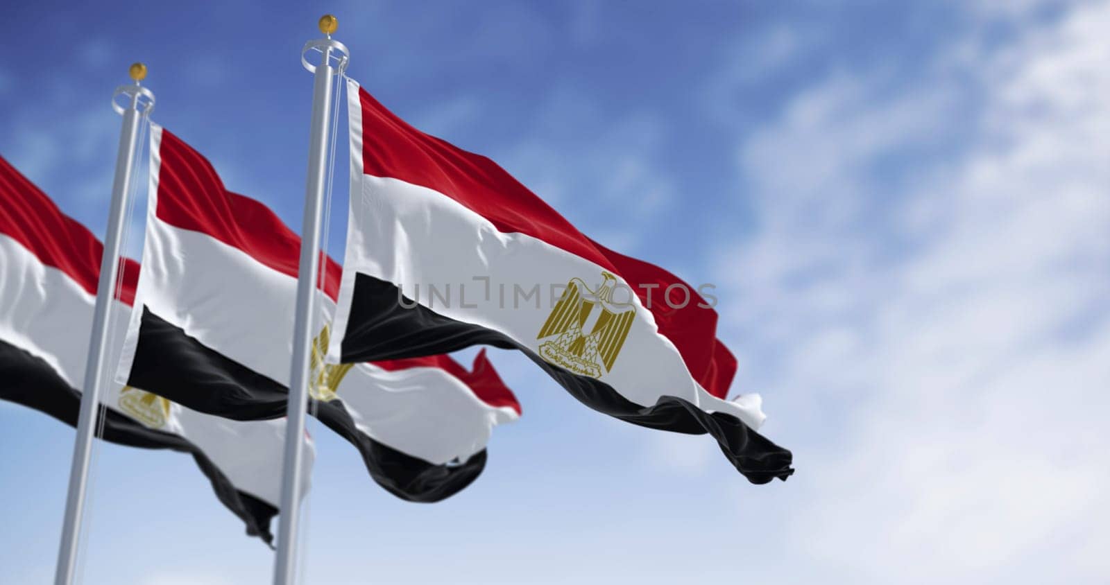 Egypt national flags waving on a clear day. Horizontal red, white and black bands. Egyptian eagle emblem centered in white band. 3d illustration render. Close-up. Selective focus