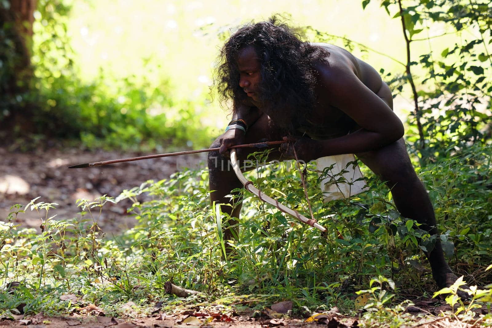 Vedda tribesman of Sri Lanka Hunting in the jungle with a bow and arrow, traditional lifestyle, and connection to nature. Tribal portrait in native Habitat. 02.03.2022 SRI LANKA.