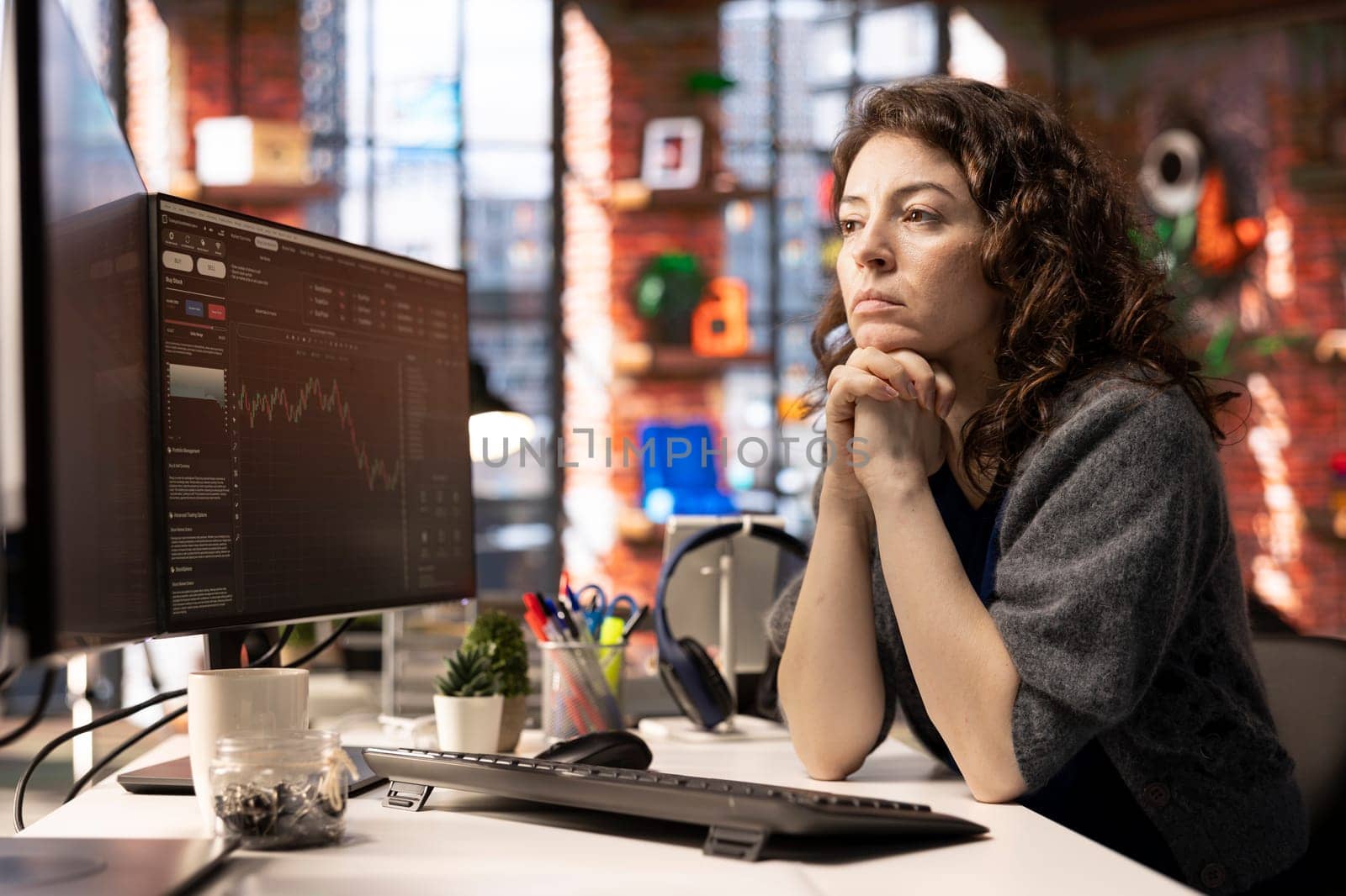 Financial investor works on PC analyzing stock market trends. The digital interface displays price fluctuations, candlestick charts. Liquidity statistics helps strategize future trading decisions.