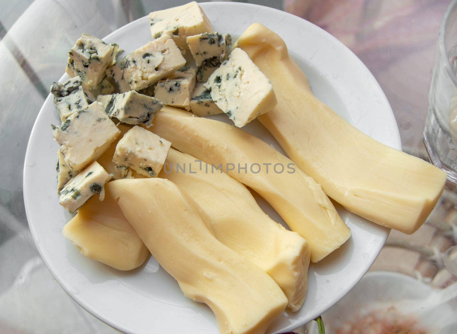 Blue cheese with noble mold, diced, on a plate, top view.
