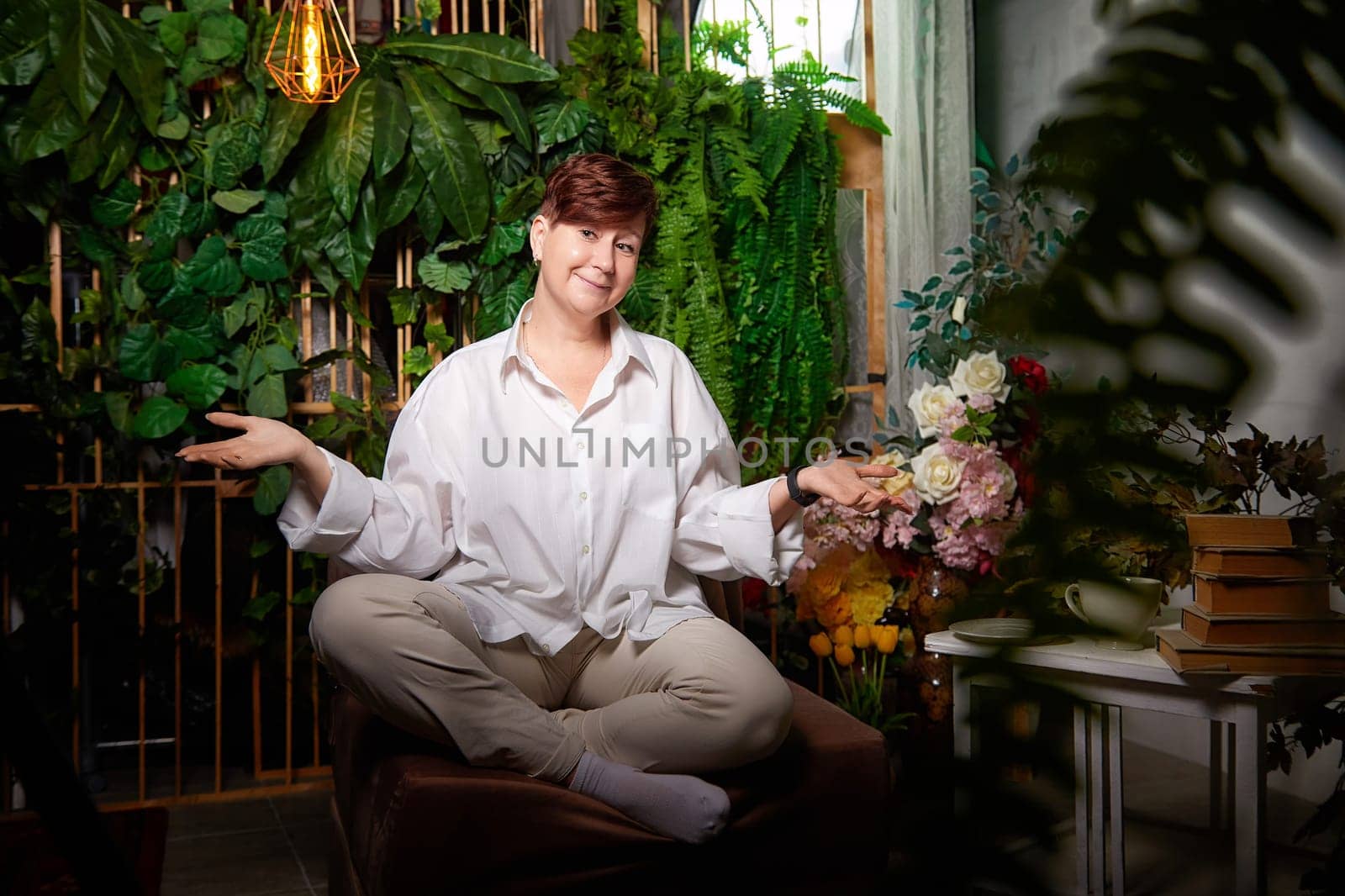 In a cozy room adorned with plants, a middle-aged woman expresses joy while engaging in her blogging activities.