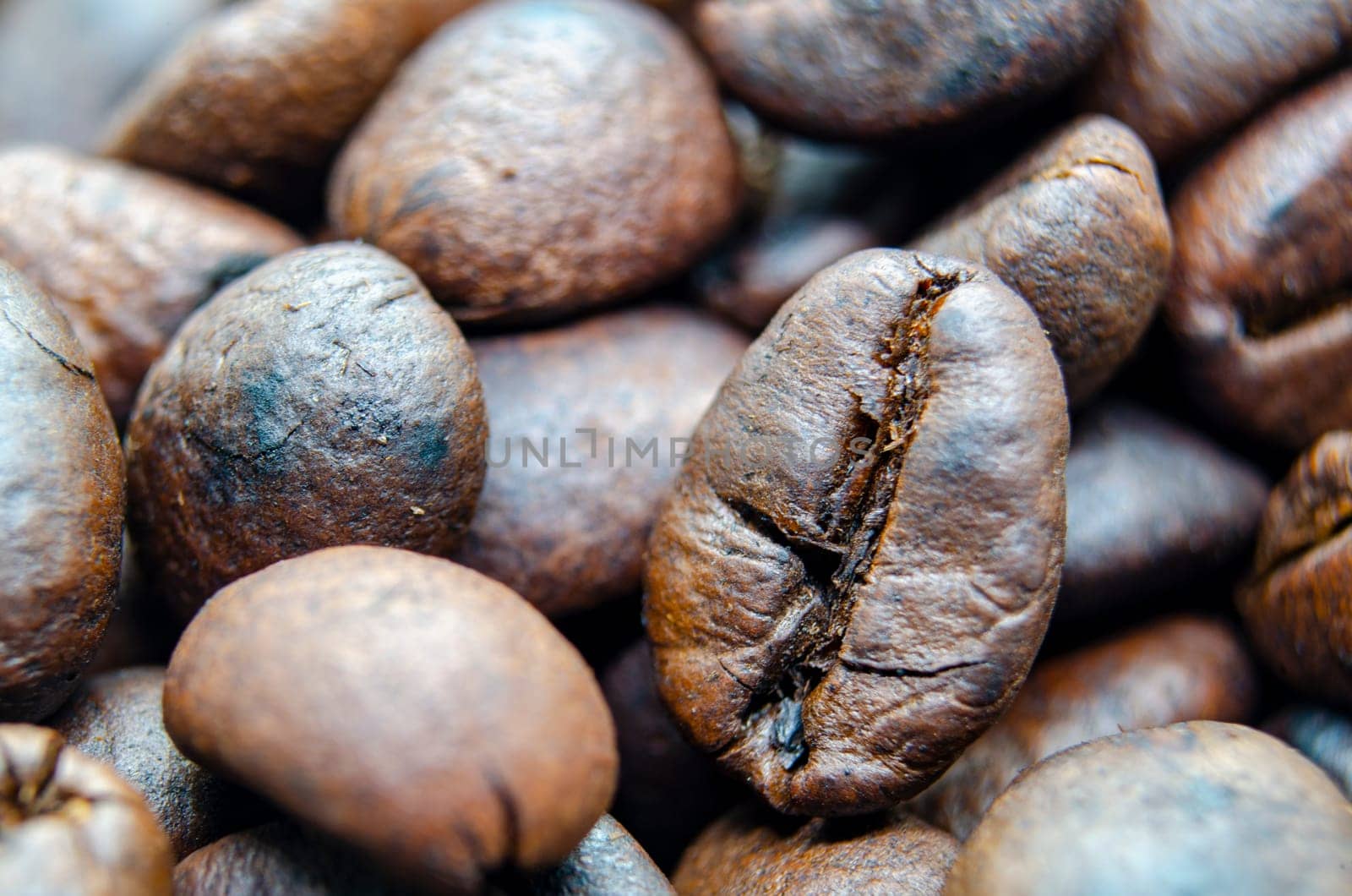 Close up of roasted coffee beans that highlights the texture and surface details of the coffee beans. Morning drinks concept.