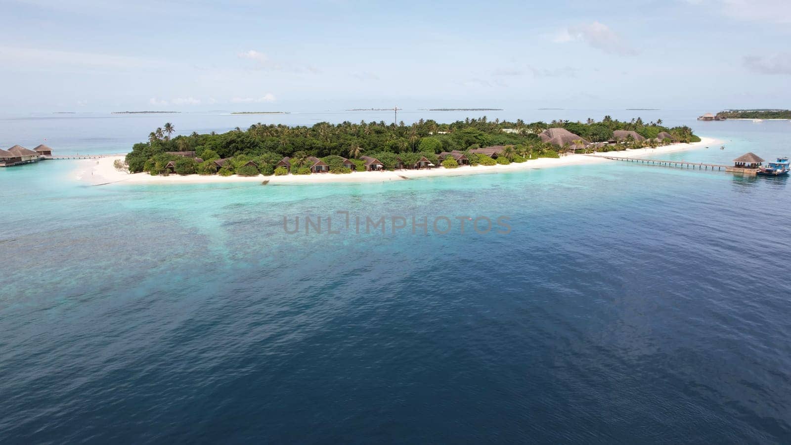 Idyllic island resort in the maldives featuring luxurious bungalows surrounded by lush vegetation, pristine white sand beaches, and a captivating turquoise lagoon