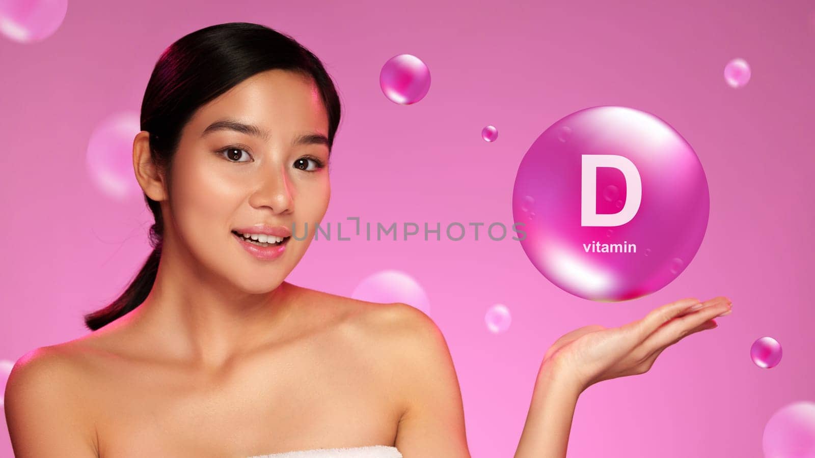 A young woman presents a graphic bubble promoting vitamin D benefits. She is smiling and enjoying the moment, exuding confidence in a vibrant pink setting.