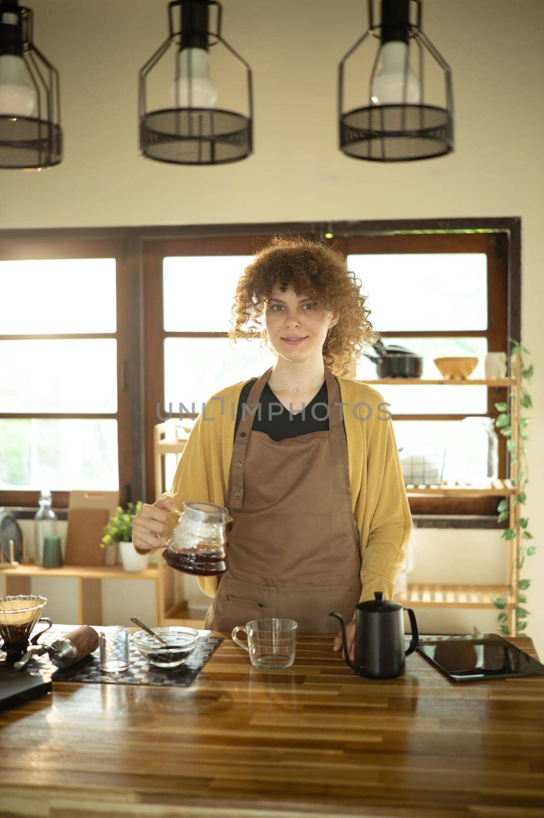 Calm young woman making a fresh cup of coffee using pour-over method.