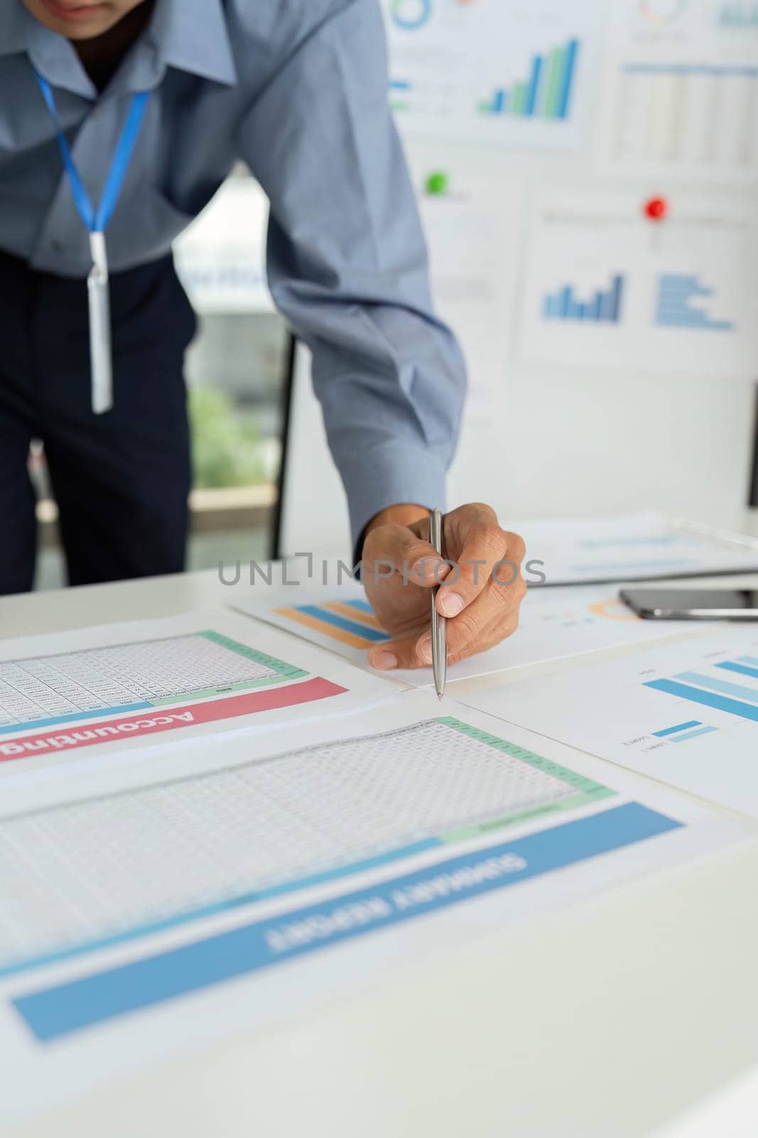 A businessman takes notes while reviewing financial data, showcasing dedication to analysis and strategic planning.