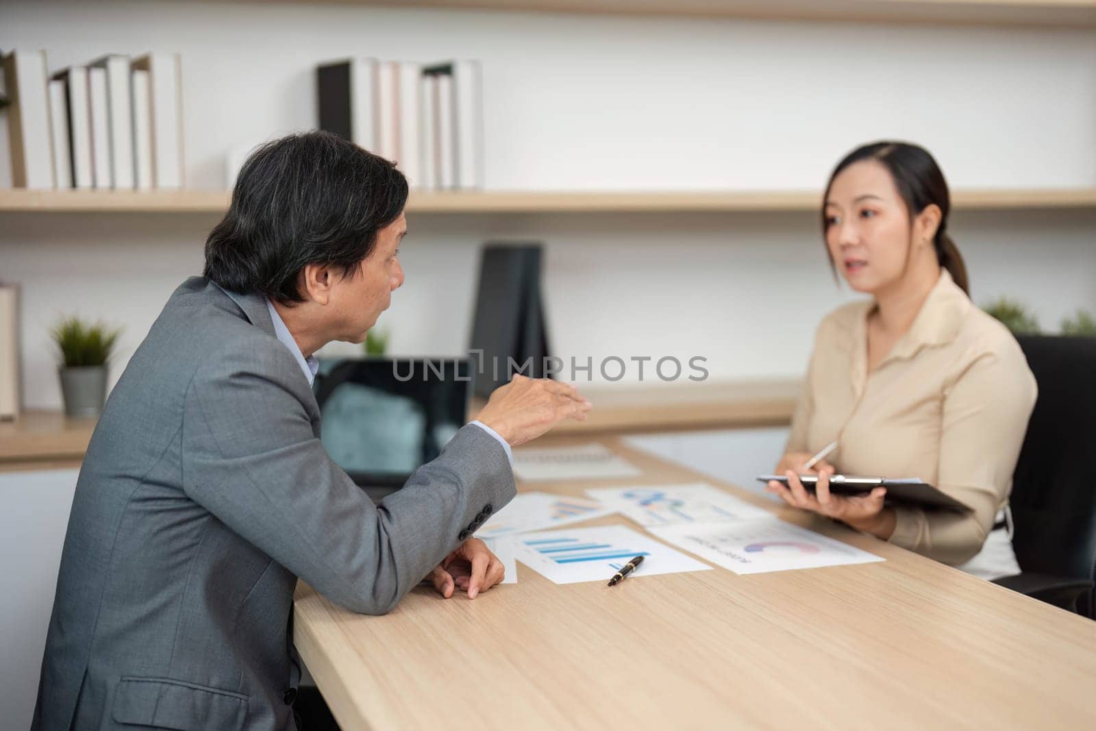 A business meeting where professionals discuss strategies and financial goals, showcasing collaboration in a modern office.