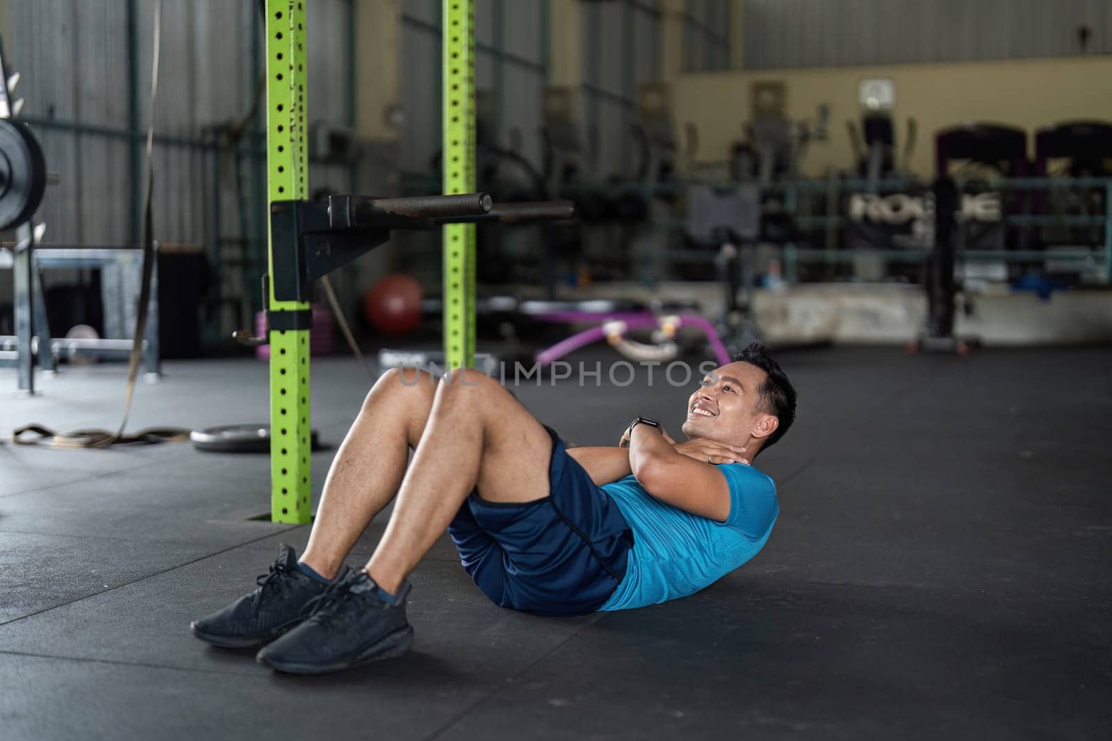 A man performs crunches in a gym, focusing on core strength and fitness as part of his workout routine.